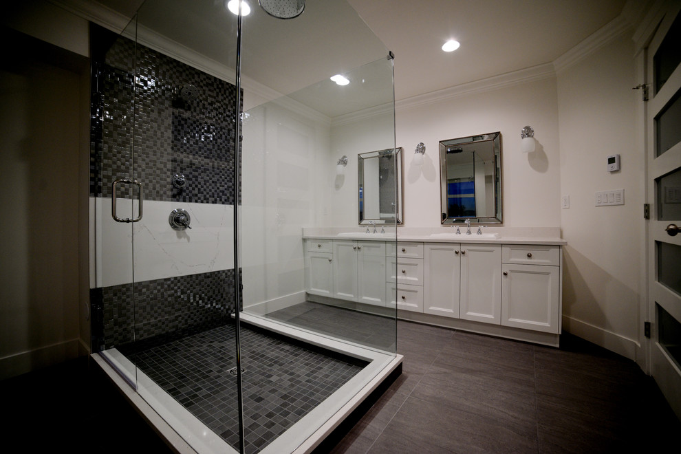 Inspiration for a large modern master bathroom in Vancouver with a freestanding tub, gray tile, porcelain floors, a drop-in sink, recessed-panel cabinets, white cabinets, mosaic tile, white walls, an alcove shower, engineered quartz benchtops, grey floor and a hinged shower door.