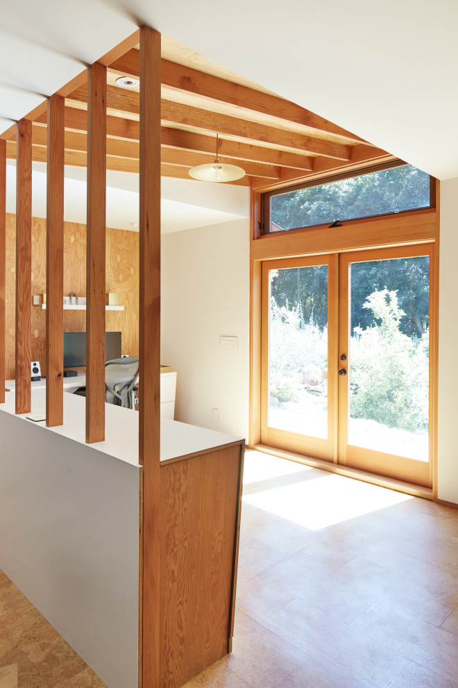 Immagine di un piccolo atelier design con pavimento in sughero, scrivania incassata, soffitto a volta e pareti in legno