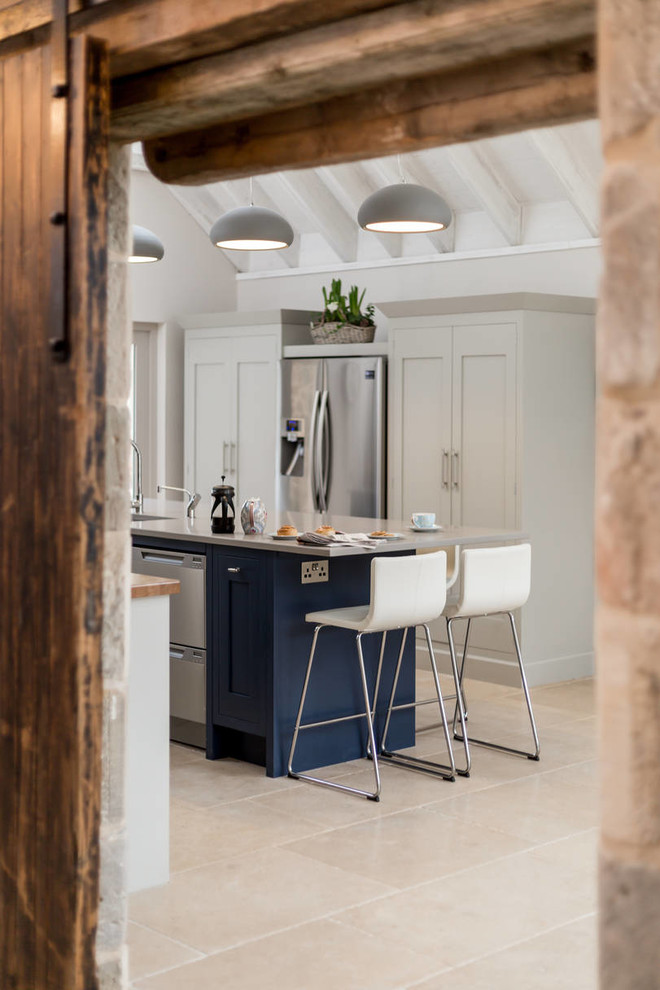 Large industrial eat-in kitchen in Edinburgh with an integrated sink, flat-panel cabinets, grey cabinets, quartzite benchtops, stainless steel appliances, travertine floors and with island.