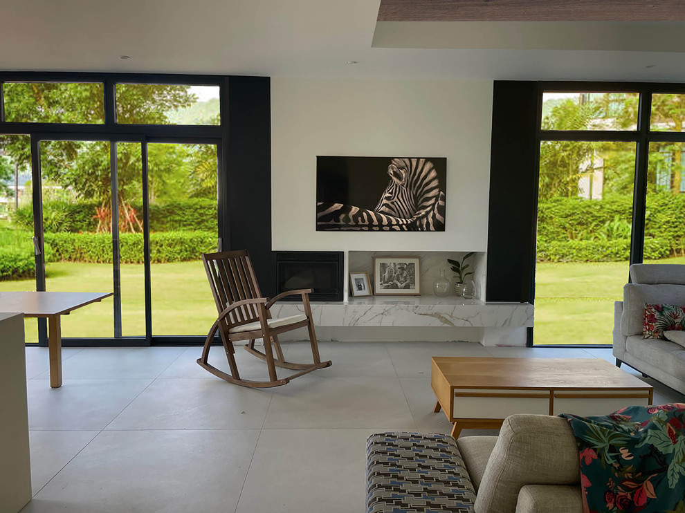 This is an example of a large contemporary open plan living room in Grenoble with white walls, ceramic flooring, a wood burning stove, a tiled fireplace surround, a concealed tv, white floors, a drop ceiling and feature lighting.