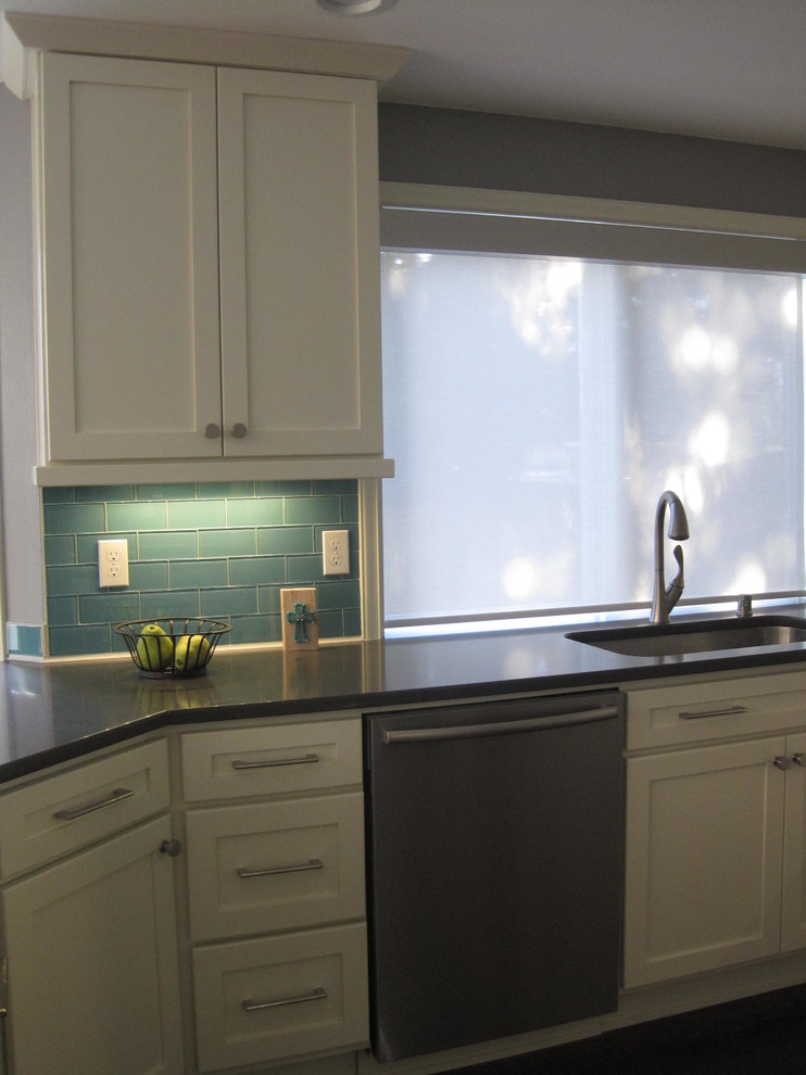 Mid-sized transitional u-shaped dark wood floor home design photo in Seattle with an undermount sink, shaker cabinets, white cabinets, quartz countertops, blue backsplash, glass tile backsplash, stainless steel appliances and a peninsula