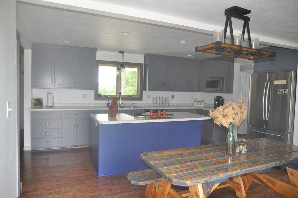 Eat-in kitchen - mid-sized transitional l-shaped medium tone wood floor and brown floor eat-in kitchen idea with a double-bowl sink, shaker cabinets, gray cabinets, marble countertops, white backsplash, stainless steel appliances, an island and gray countertops