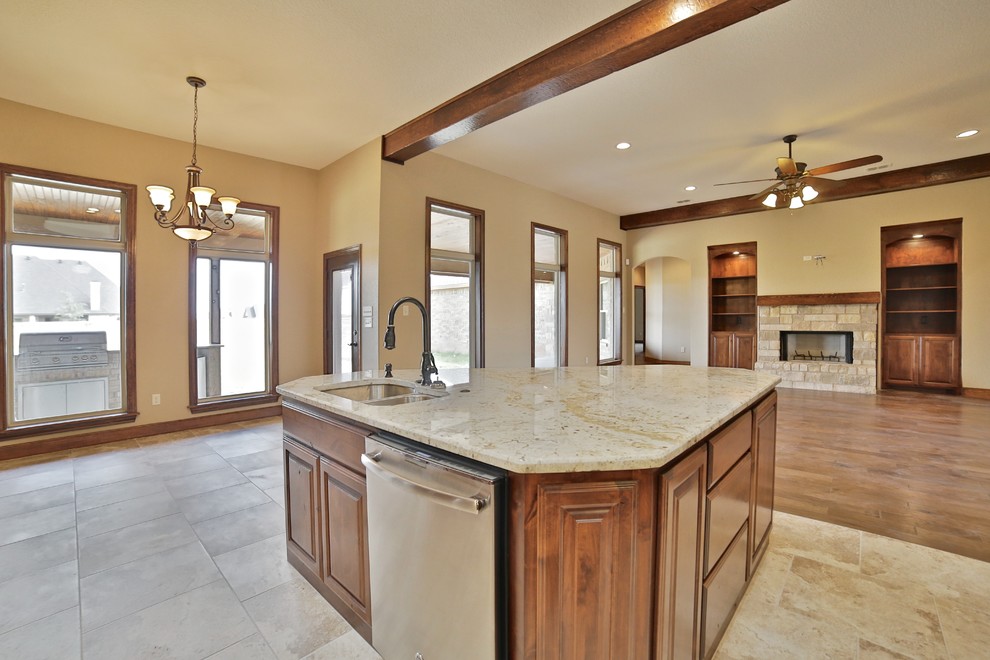 Eat-in kitchen - mid-sized rustic l-shaped porcelain tile eat-in kitchen idea in Dallas with an undermount sink, raised-panel cabinets, medium tone wood cabinets, granite countertops, beige backsplash, stone tile backsplash, stainless steel appliances and an island
