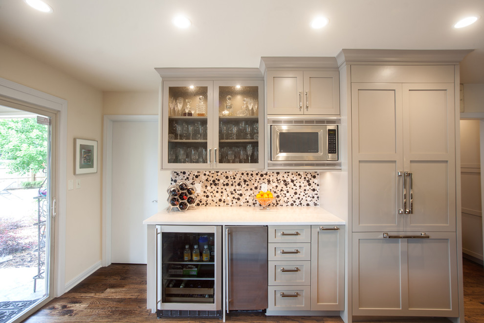 Large transitional l-shaped dark wood floor and brown floor enclosed kitchen photo in Other with shaker cabinets, quartz countertops, stainless steel appliances, gray cabinets, multicolored backsplash, glass tile backsplash and an island