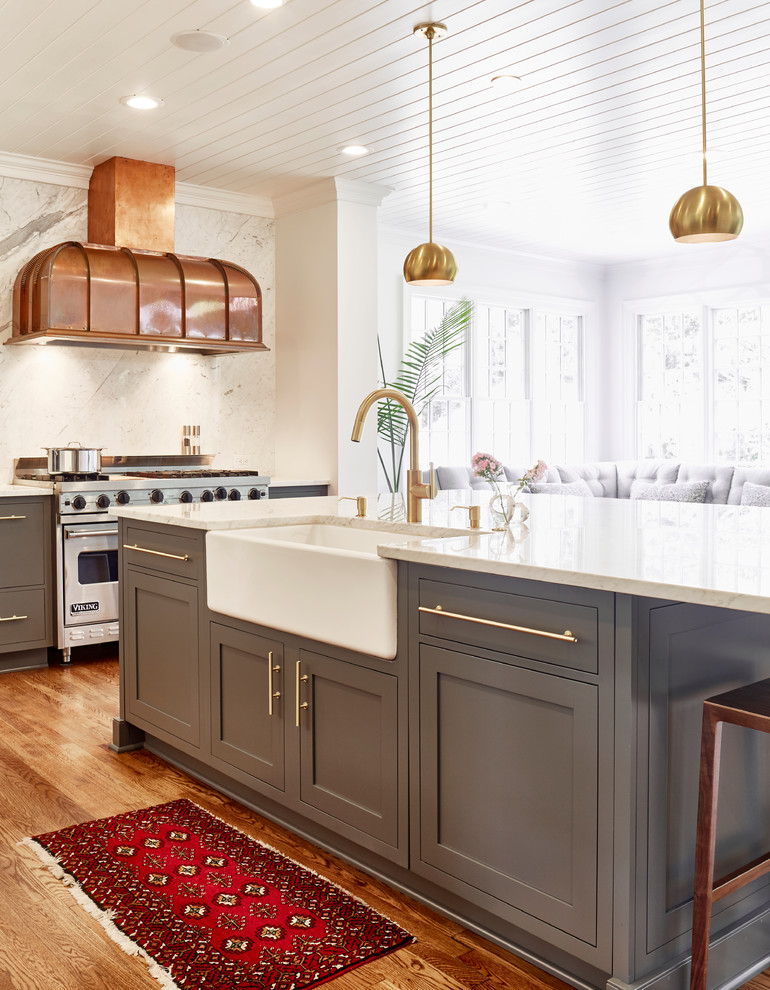 Inspiration for a large transitional l-shaped open plan kitchen in Other with a farmhouse sink, shaker cabinets, grey cabinets, marble benchtops, white splashback, marble splashback, panelled appliances, medium hardwood floors, with island and brown floor.