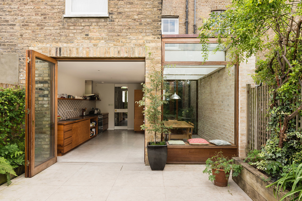 Mid-sized contemporary brick beige townhouse exterior in London.