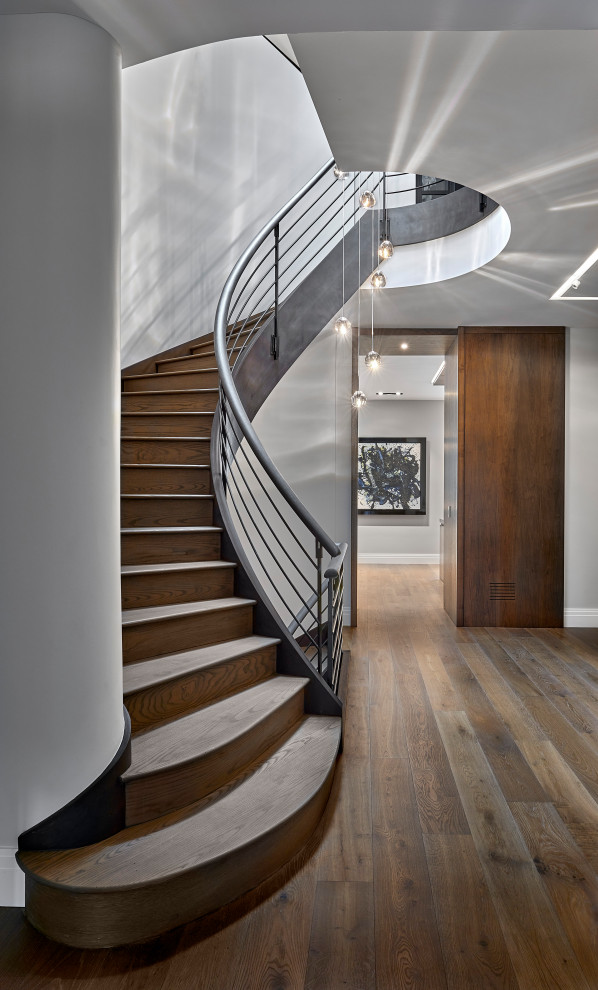 Стильный дизайн: изогнутая лестница в стиле модернизм с металлическими перилами - последний тренд