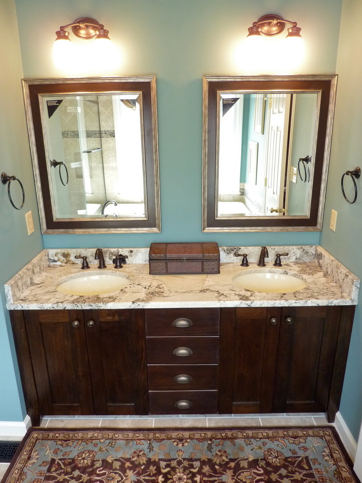 Small transitional master bathroom in Charlotte with an undermount sink, flat-panel cabinets, dark wood cabinets, granite benchtops, a drop-in tub, a corner shower, a two-piece toilet, beige tile, porcelain tile, blue walls and porcelain floors.