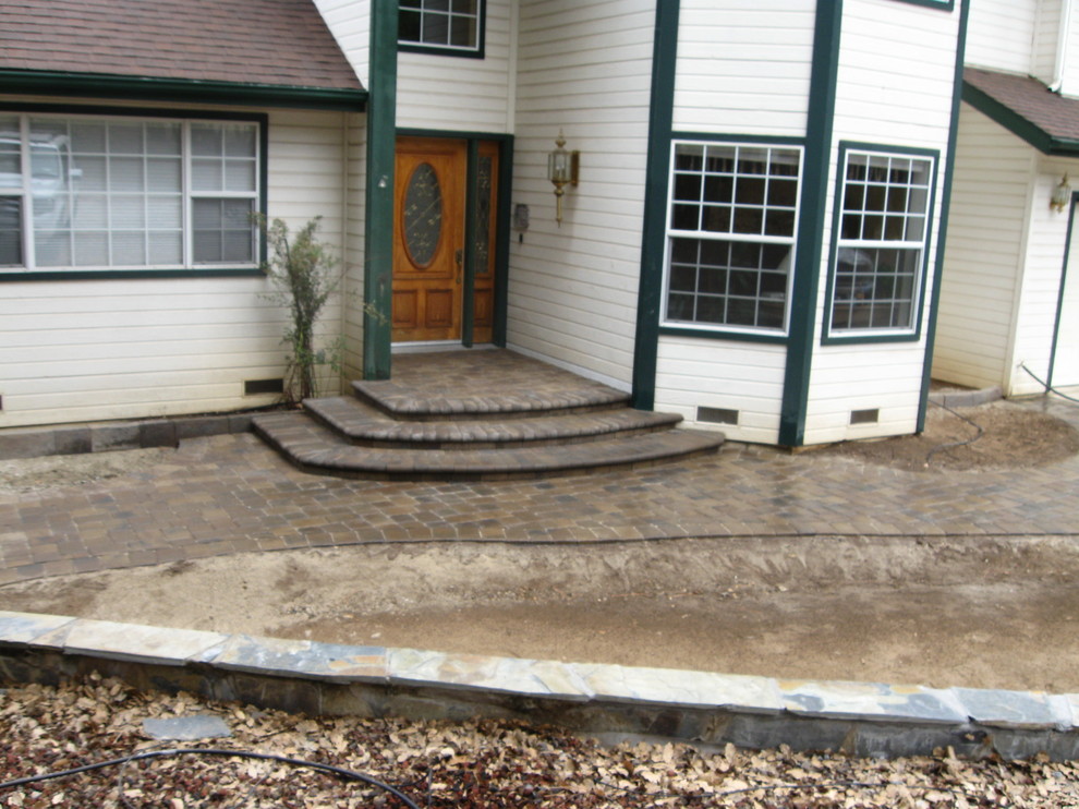 Mid-sized mountain style concrete paver front porch idea