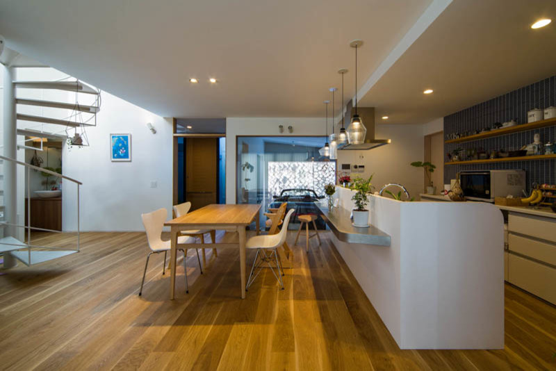 Photo of a mid-sized modern kitchen/dining combo in Kobe with white walls, medium hardwood floors, wallpaper and wallpaper.