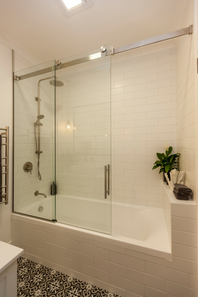 Design ideas for a modern master bathroom in Wellington with shaker cabinets, white cabinets, a corner shower, a one-piece toilet, white tile, subway tile, white walls, ceramic floors, a vessel sink, engineered quartz benchtops, multi-coloured floor, a hinged shower door and white benchtops.