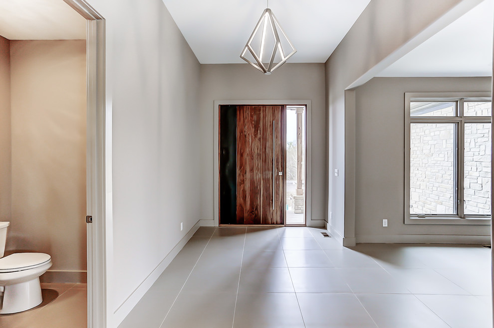 Design ideas for a mid-sized transitional foyer in Other with beige walls, porcelain floors, a pivot front door, a medium wood front door and beige floor.