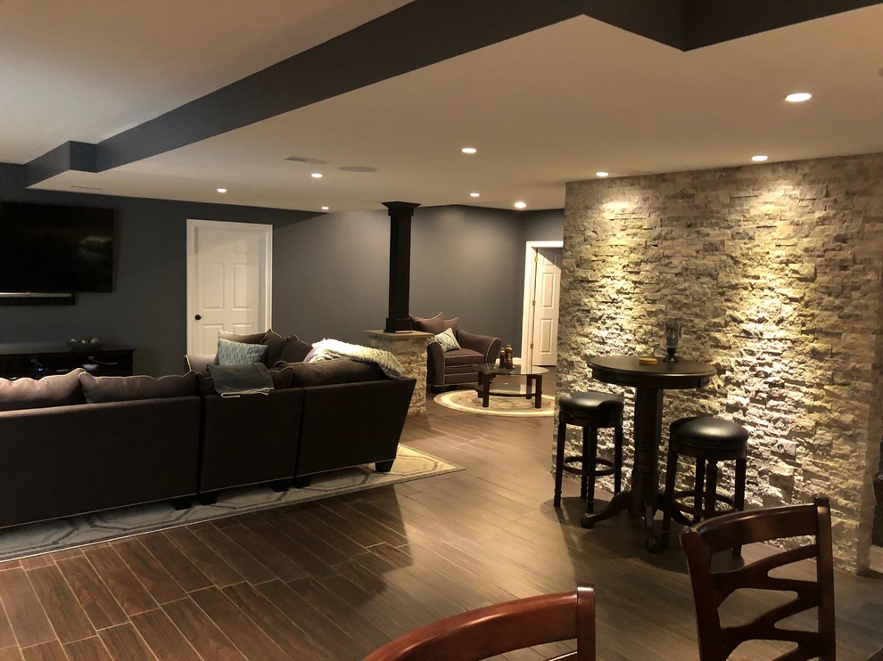 Basement - large modern underground brown floor basement idea in Philadelphia with gray walls