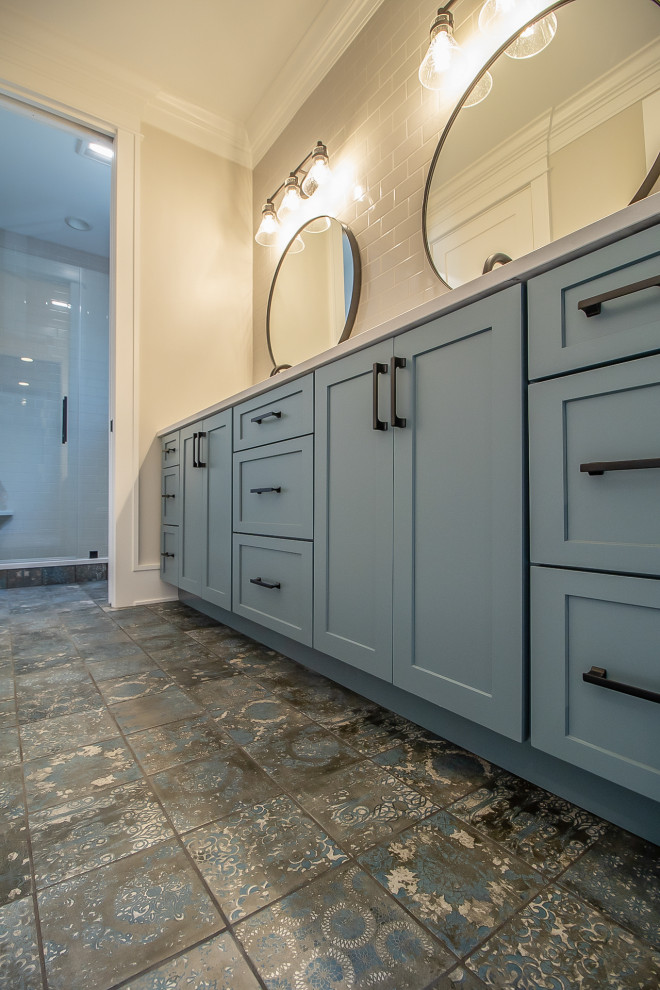 Exempel på ett stort klassiskt blå blått en-suite badrum, med luckor med infälld panel, blå skåp, beige kakel, tunnelbanekakel, beige väggar, klinkergolv i keramik, ett nedsänkt handfat och flerfärgat golv