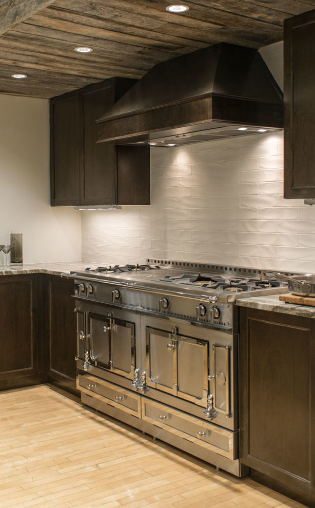 Transitional light wood floor kitchen photo in Boston with dark wood cabinets, granite countertops, white backsplash, subway tile backsplash and stainless steel appliances