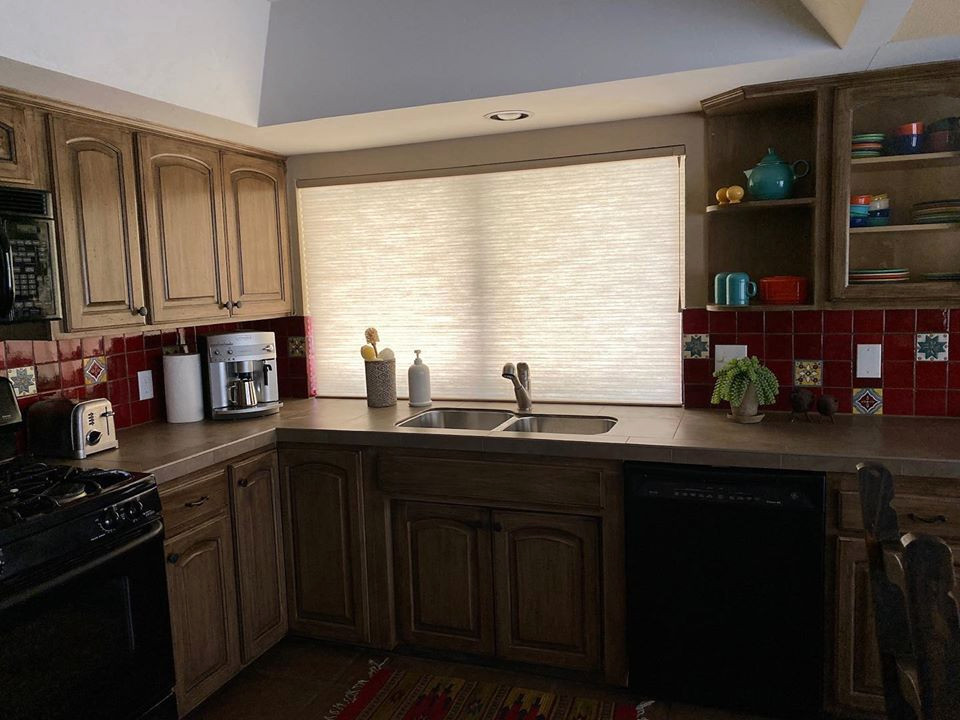 Mid-sized single-wall eat-in kitchen in Phoenix with a double-bowl sink, open cabinets, light wood cabinets, tile benchtops, red splashback, glass tile splashback, black appliances, ceramic floors, with island, brown floor, brown benchtop and vaulted.