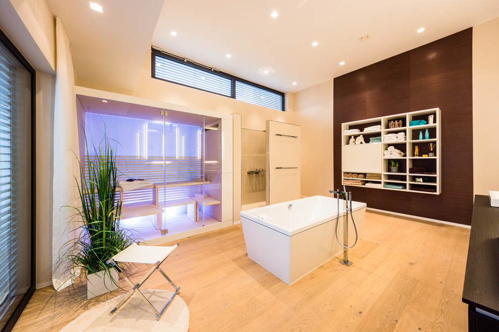 This is an example of a large contemporary bathroom in Frankfurt with white cabinets, wood benchtops, a hot tub, glass tile, white walls, medium hardwood floors, open cabinets, beige tile and with a sauna.
