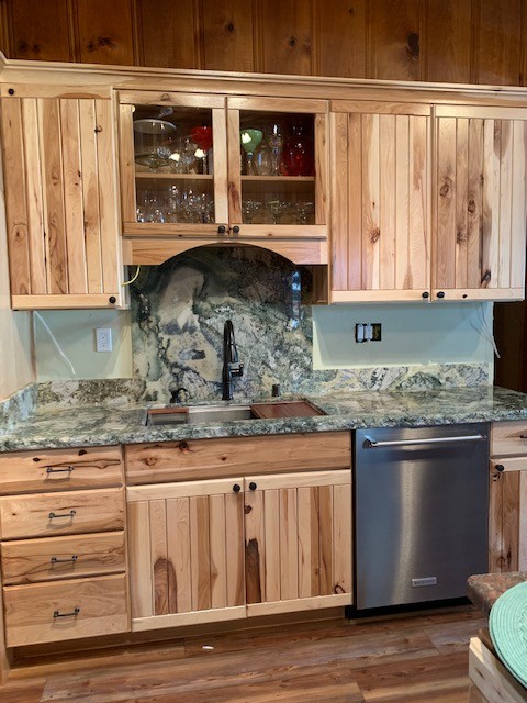 Inspiration for a mid-sized rustic medium tone wood floor and brown floor open concept kitchen remodel with an undermount sink, flat-panel cabinets, light wood cabinets, granite countertops, gray backsplash, stone slab backsplash, stainless steel appliances and gray countertops