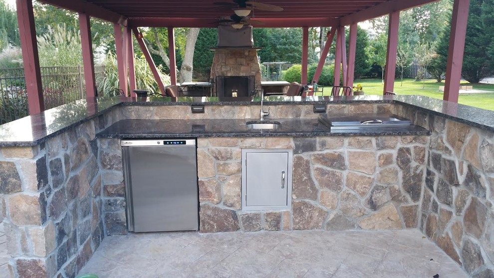 Large country backyard patio in New York with an outdoor kitchen, concrete slab and a gazebo/cabana.