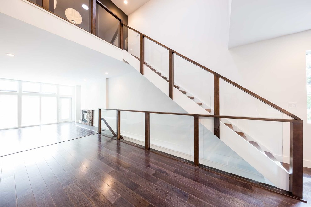 Design ideas for a mid-sized modern carpeted straight staircase in Edmonton with open risers and wood railing.