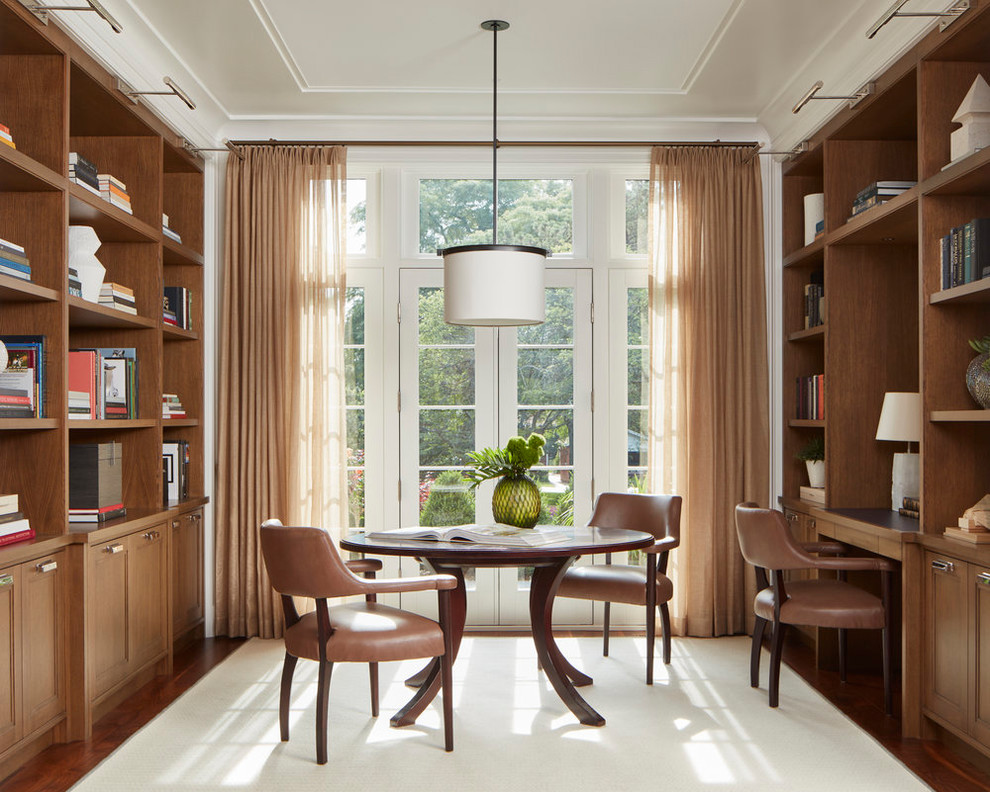 Photo of a transitional home office in Chicago with dark hardwood floors, a built-in desk and brown floor.