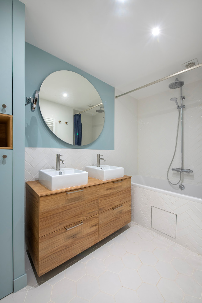Idées déco pour une salle de bain principale moderne en bois brun de taille moyenne avec un placard à porte affleurante, une baignoire posée, un combiné douche/baignoire, un carrelage blanc, des carreaux en terre cuite, un mur bleu, un sol en carrelage de céramique, une vasque, un plan de toilette en bois, un sol gris, aucune cabine, un plan de toilette beige, buanderie, meuble double vasque et meuble-lavabo sur pied.