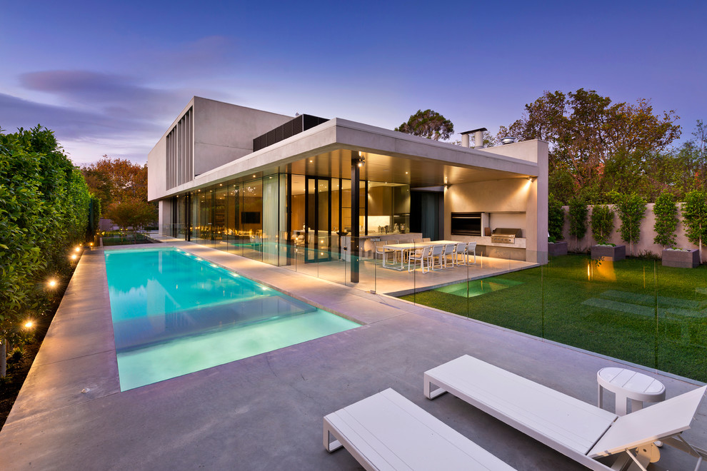 Photo of a large modern backyard rectangular lap pool in Melbourne with concrete slab.