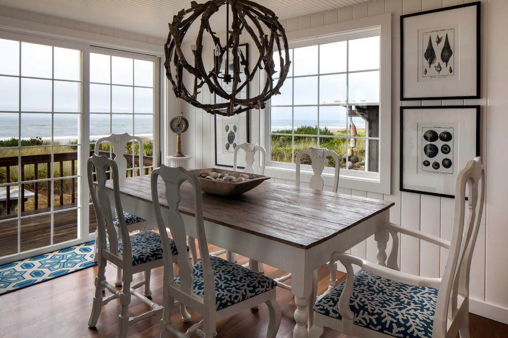 This is an example of a beach style dining room in Seattle with medium hardwood floors and white walls.