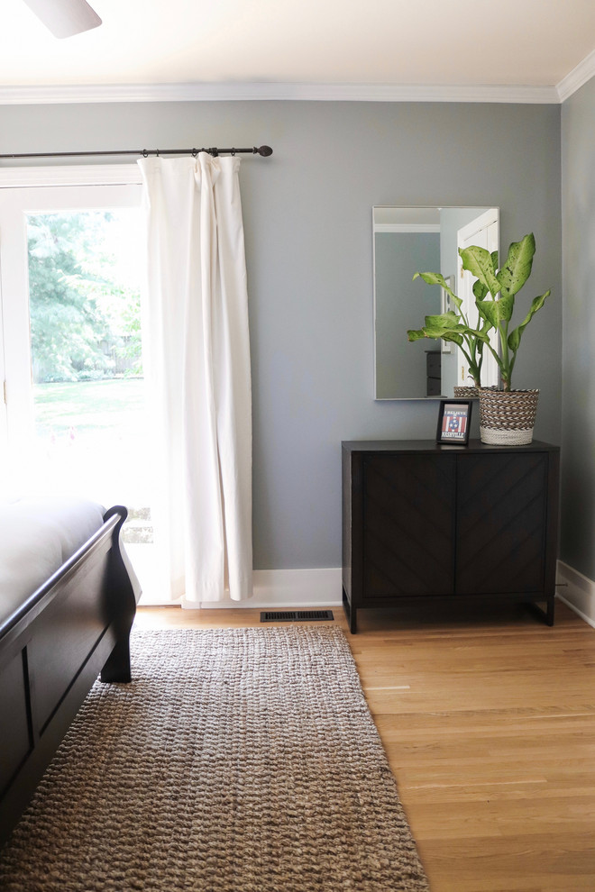 This is an example of a mid-sized transitional master bedroom with blue walls and medium hardwood floors.
