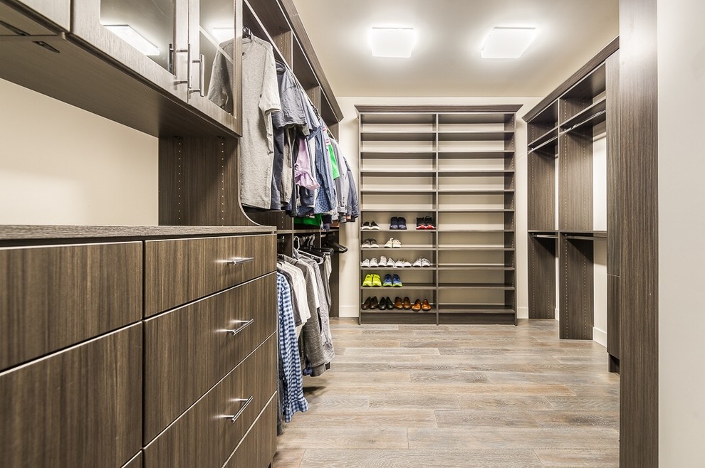 Inspiration for a large modern gender-neutral walk-in wardrobe in Phoenix with medium wood cabinets and light hardwood floors.