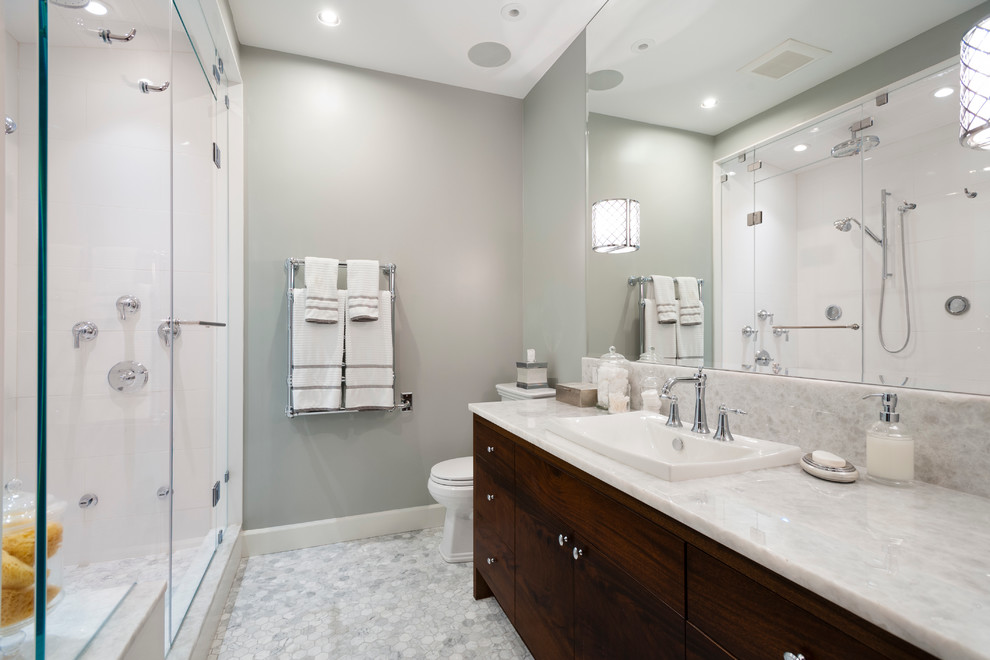 Mid-sized transitional master bathroom in Vancouver with a drop-in sink, flat-panel cabinets, dark wood cabinets, onyx benchtops, a corner shower, a one-piece toilet, white tile, stone tile, grey walls and marble floors.