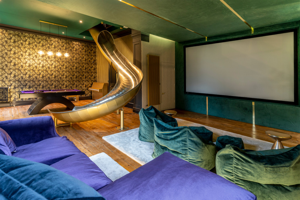 Idee per un home theatre contemporaneo aperto con pareti verdi, pavimento in legno massello medio, schermo di proiezione e pavimento marrone