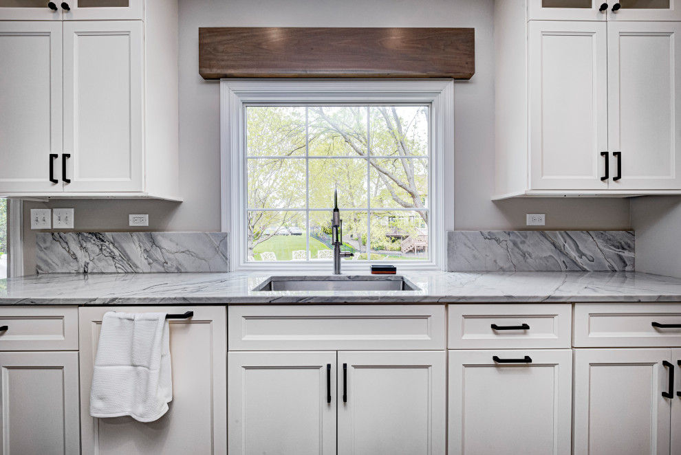 Immagine di una cucina minimal di medie dimensioni con lavello sottopiano, ante in stile shaker, ante bianche, top in granito, paraspruzzi in granito, paraspruzzi grigio e top grigio