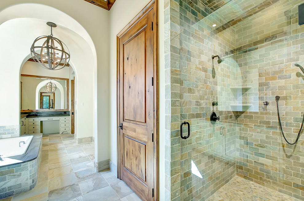 Large country master bathroom in Dallas with shaker cabinets, beige cabinets, a drop-in tub, an alcove shower, stone tile, beige walls, slate floors and an undermount sink.