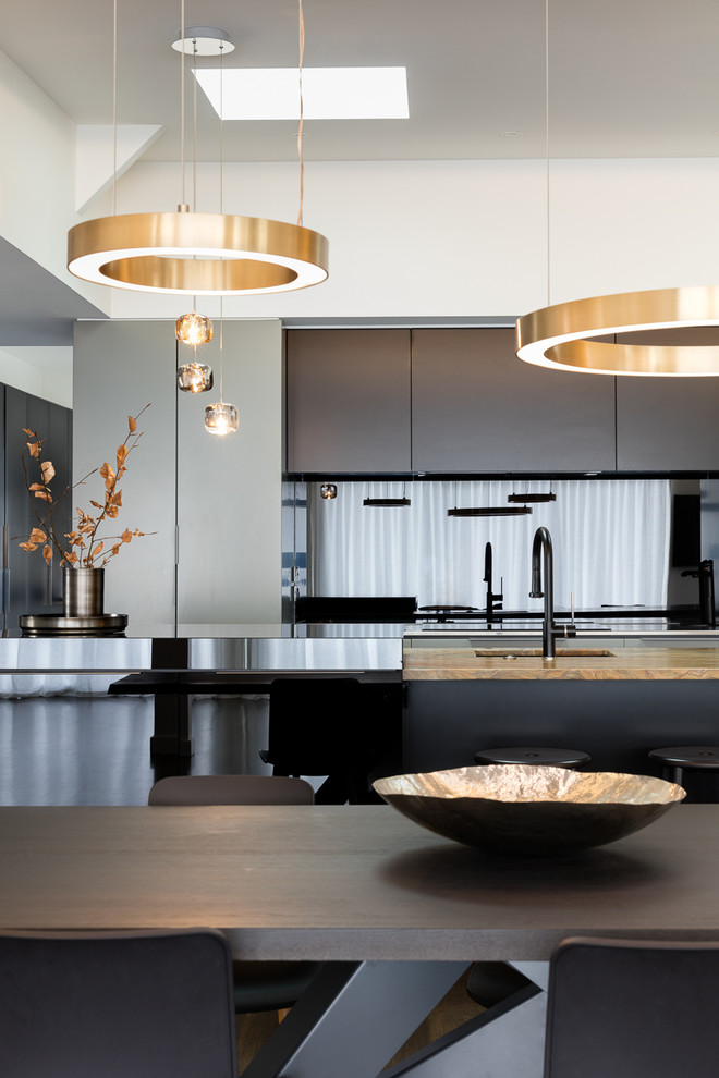 This is an example of a contemporary kitchen in Auckland with metallic splashback and glass sheet splashback.