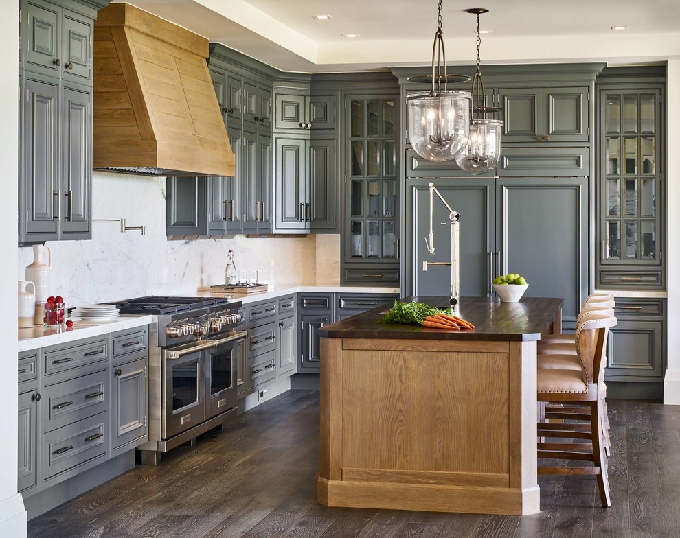 Inspiration for a large traditional l-shaped kitchen in Denver with grey cabinets, white splashback, dark hardwood floors, with island, brown floor, white benchtop, glass-front cabinets and panelled appliances.