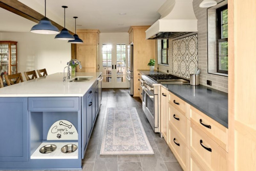 This kitchen was thoughtfully designed with dogs in mind, featuring a built-in feeding station at the end of a spacious island.