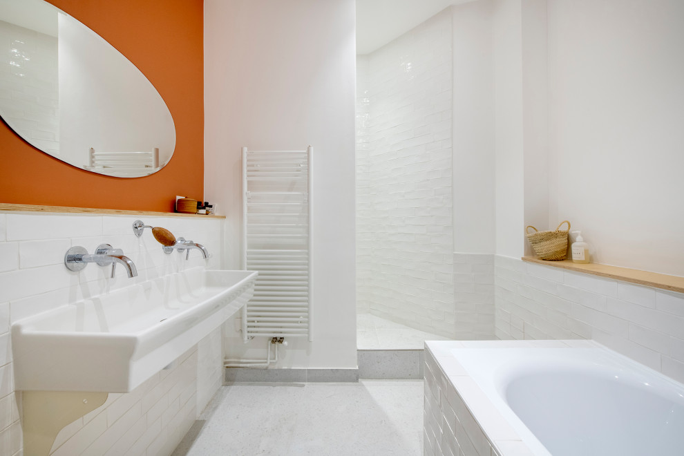 This is an example of a large traditional master bathroom in Paris with open cabinets, white cabinets, a drop-in tub, a shower/bathtub combo, white tile, terra-cotta tile, white walls, terrazzo floors, a trough sink, solid surface benchtops, white floor, an open shower, white benchtops and a double vanity.
