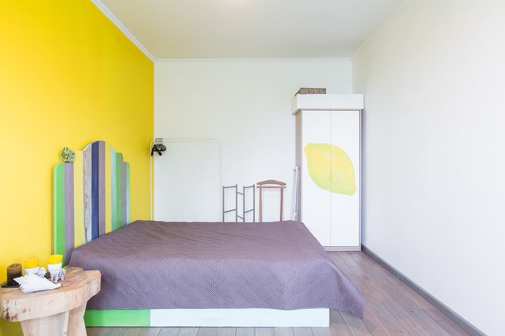 This is an example of a scandinavian master bedroom in Moscow with yellow walls and medium hardwood floors.