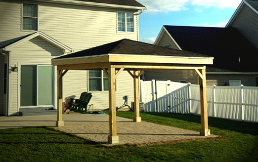Photo of a mid-sized arts and crafts backyard patio in Other with a gazebo/cabana and brick pavers.