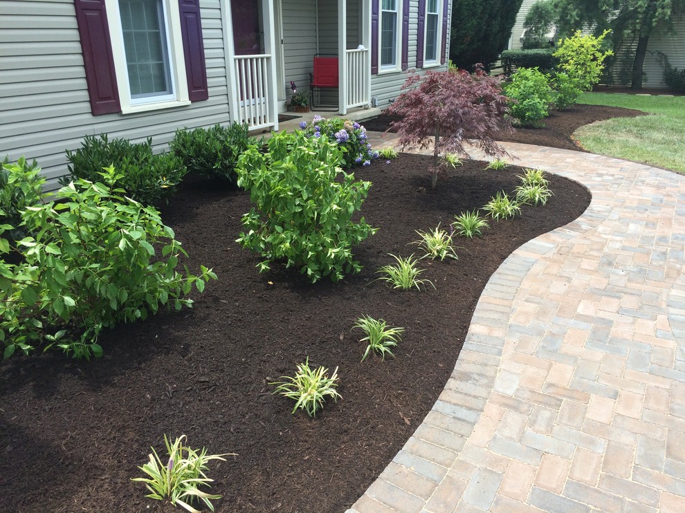 This is an example of a mid-sized country front yard driveway in Wilmington with a garden path and brick pavers.