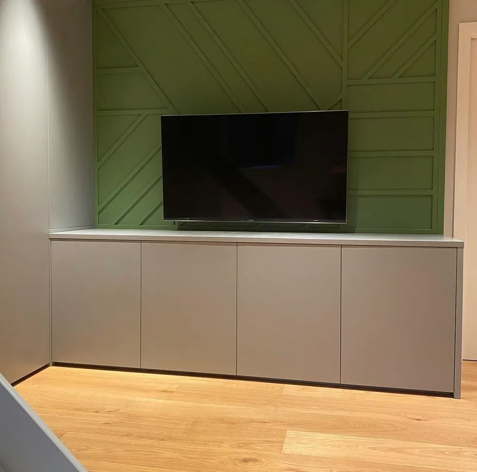 Design ideas for a medium sized contemporary games room in Hertfordshire with green walls, light hardwood flooring, a wall mounted tv, panelled walls and a feature wall.