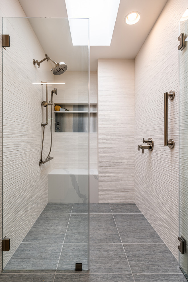 Photo of a large contemporary bathroom in Sacramento with flat-panel cabinets, light wood cabinets, a curbless shower, a two-piece toilet, white tile, cement tile, beige walls, ceramic floors, a drop-in sink, marble benchtops, grey floor, a hinged shower door and white benchtops.