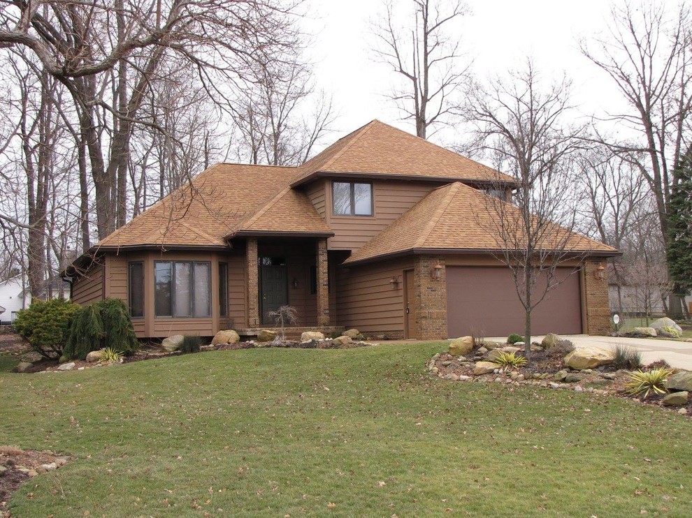 Design ideas for a mid-sized traditional two-storey beige exterior in Cleveland with wood siding and a hip roof.