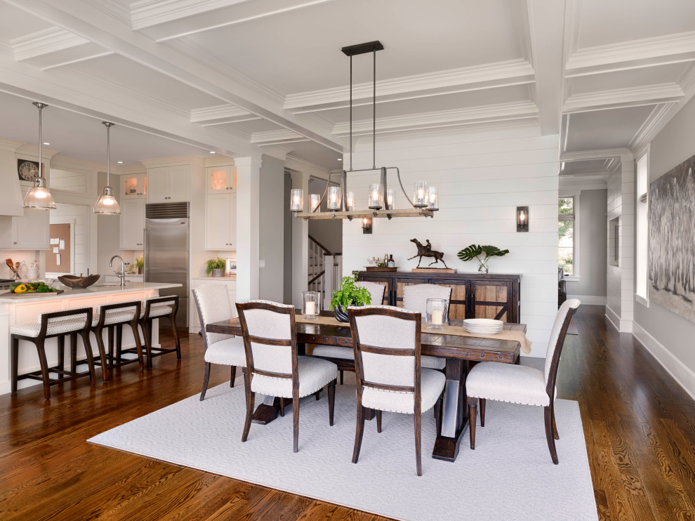 Large transitional kitchen/dining combo with white walls, medium hardwood floors, coffered and panelled walls.