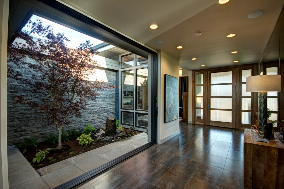 Design ideas for an expansive contemporary foyer in Portland with grey walls, porcelain floors, a single front door, a medium wood front door and multi-coloured floor.