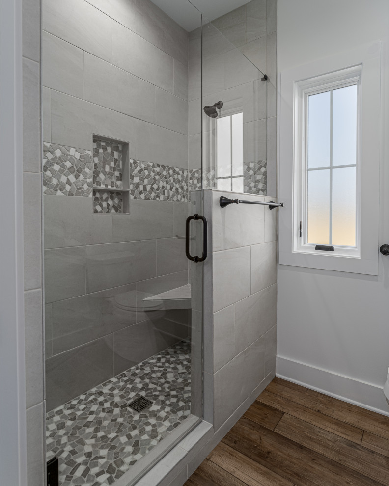 Пример оригинального дизайна: ванная комната среднего размера в стиле кантри с фасадами в стиле шейкер, белыми фасадами, душем в нише, раздельным унитазом, бежевой плиткой, керамической плиткой, бежевыми стенами, полом из винила, душевой кабиной, врезной раковиной, столешницей из искусственного кварца, коричневым полом, душем с распашными дверями, бежевой столешницей, сиденьем для душа, тумбой под две раковины и встроенной тумбой