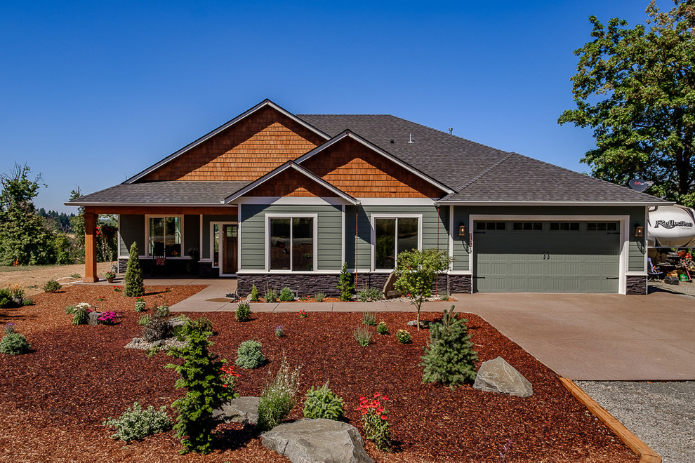Inspiration for a rustic green one-story vinyl house exterior remodel in Portland with a shingle roof