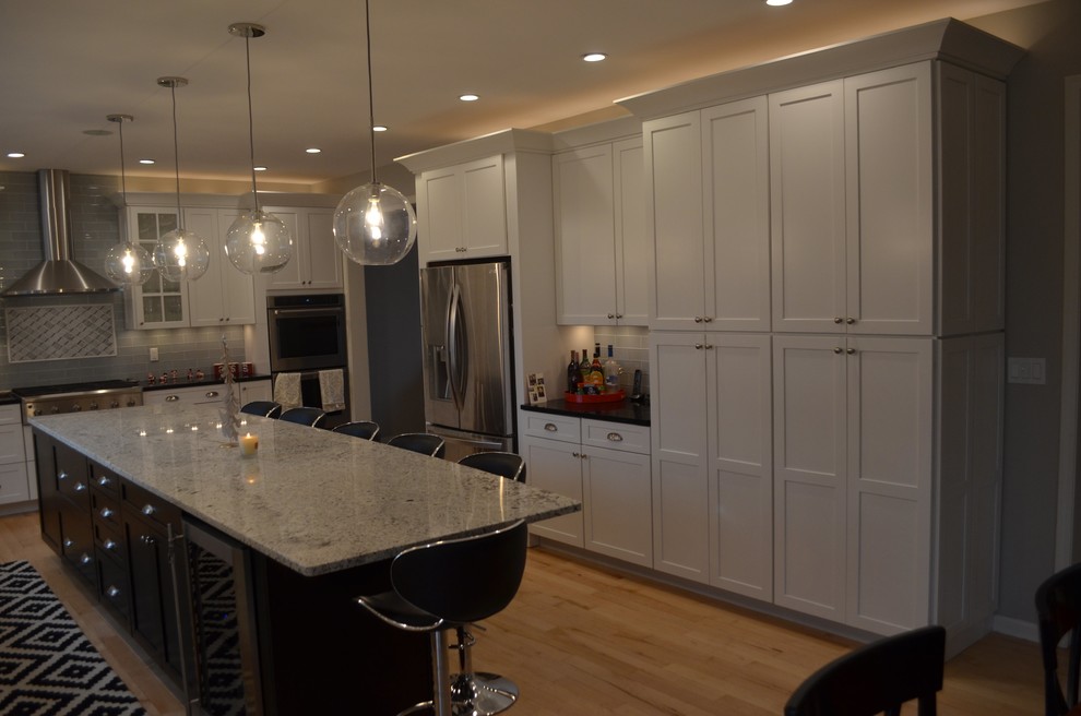Example of a mid-sized transitional single-wall eat-in kitchen design with shaker cabinets, white cabinets, quartz countertops and an island