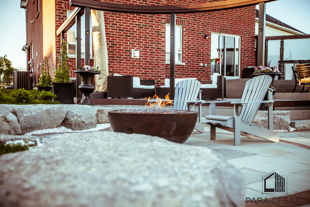 Large minimalist backyard deck photo in Toronto with a fire pit and no cover
